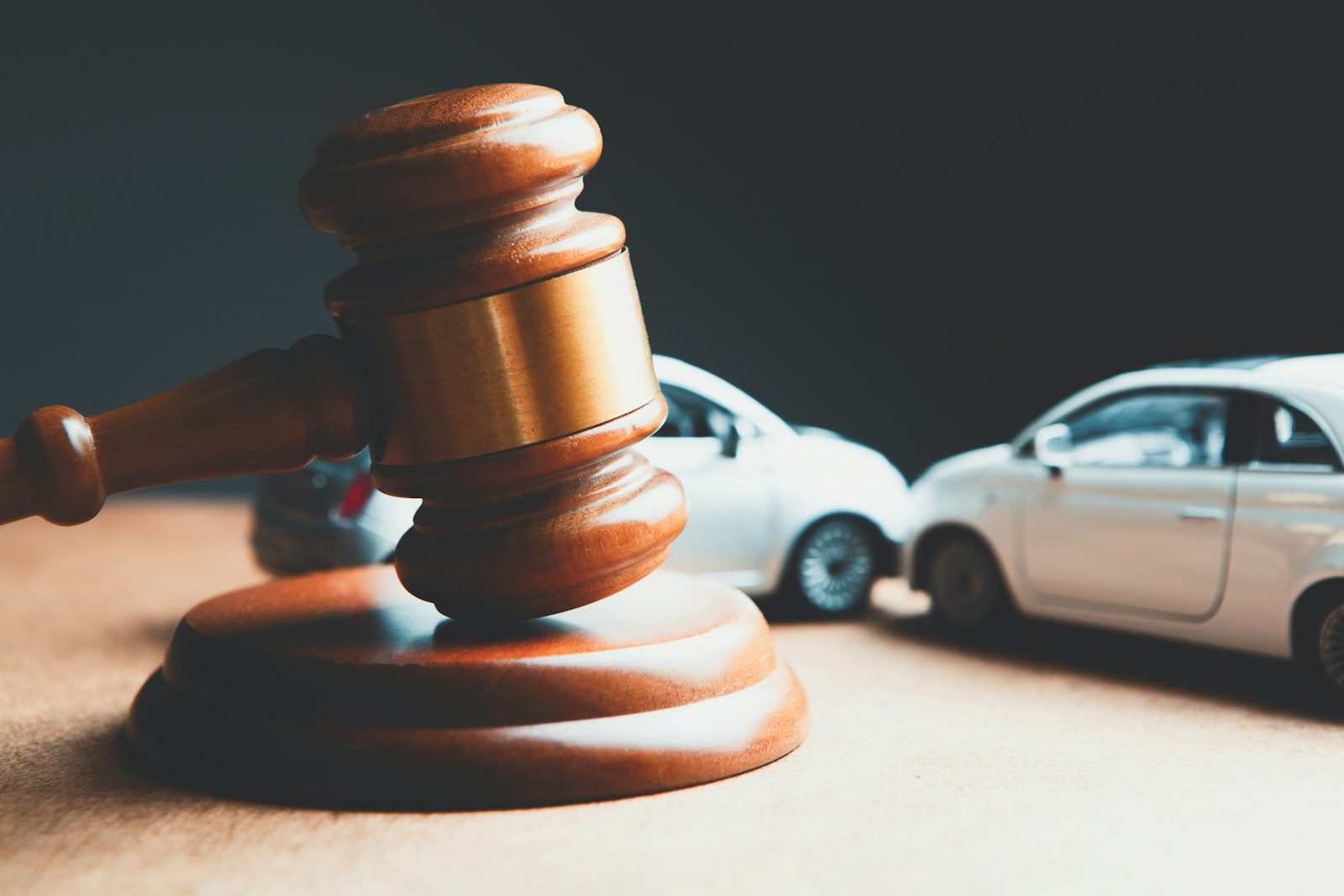 a toy car and a wooden gaven on a table; car accident investigations