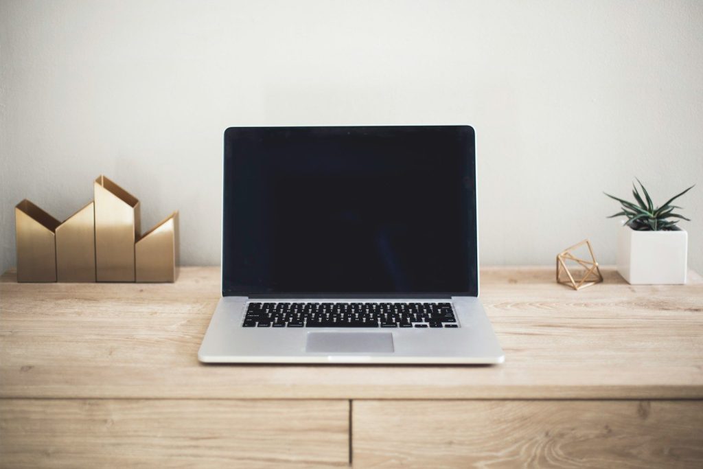 MacBook Pro on top of brown table; open source risk management