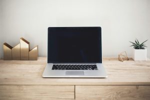 MacBook Pro on top of brown table; open source risk management
