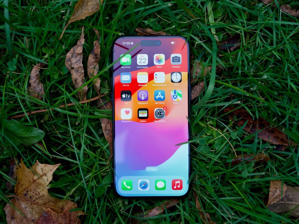 a close up of a cell phone laying in the grass