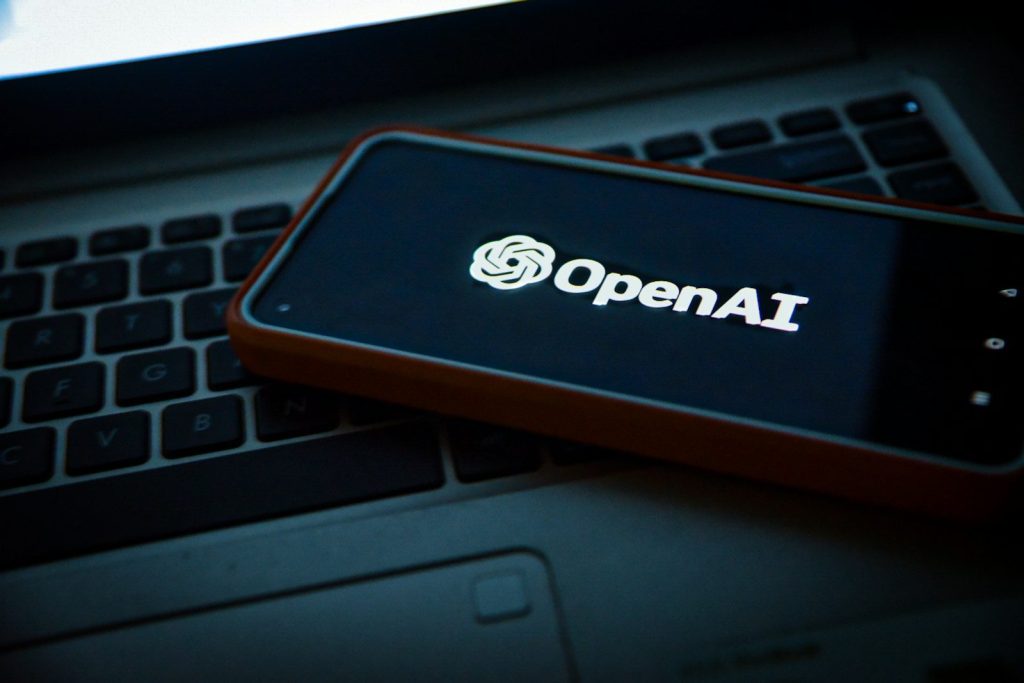 a cell phone sitting on top of a laptop computer; GPT-6 Sol and Luna