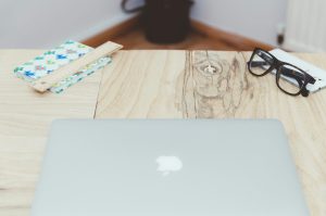 an empty desk with an apple laptop
