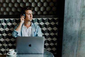 a man on a laptop sitting in a booth