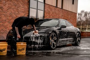 someone washing a black car