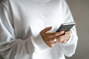 person in white long sleeve shirt holding black smartphone; free PR for founders