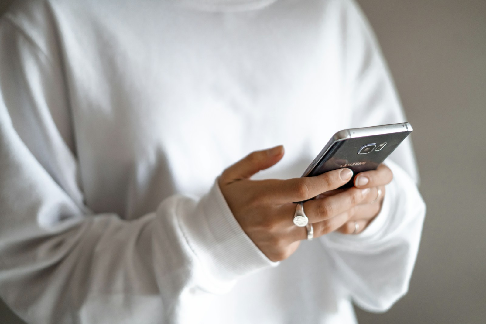 person in white long sleeve shirt holding black smartphone; free PR for founders