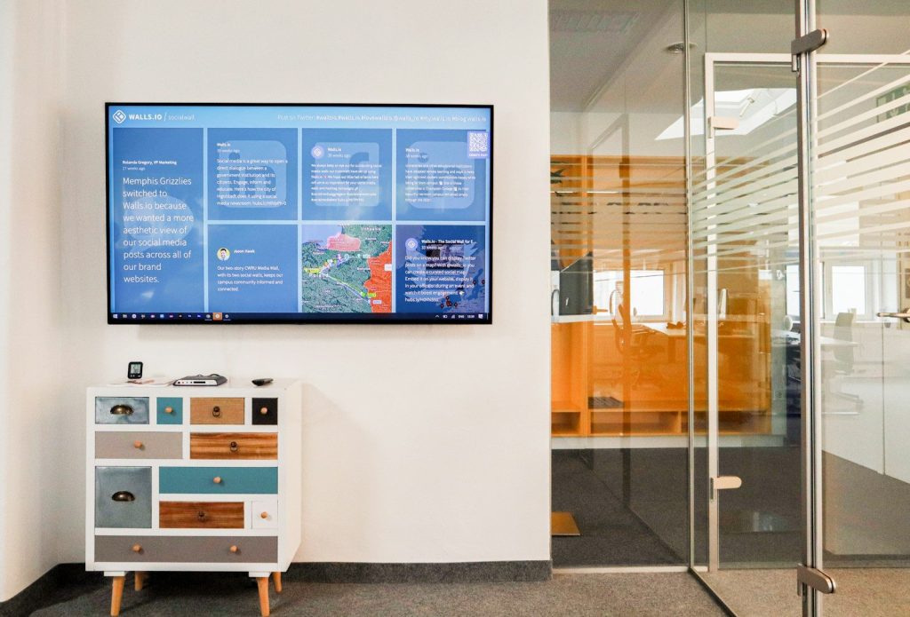 a television mounted to a wall in a room; office displays