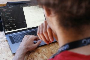 a man sitting at a table using a laptop computer; AI infrastructure deployment