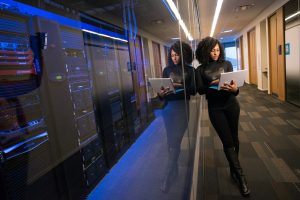 woman in black top using Surface laptop; compliance-ready IT infrastructure