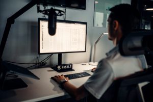 man in white polo shirt sitting in front of computer; voice AI endpointing