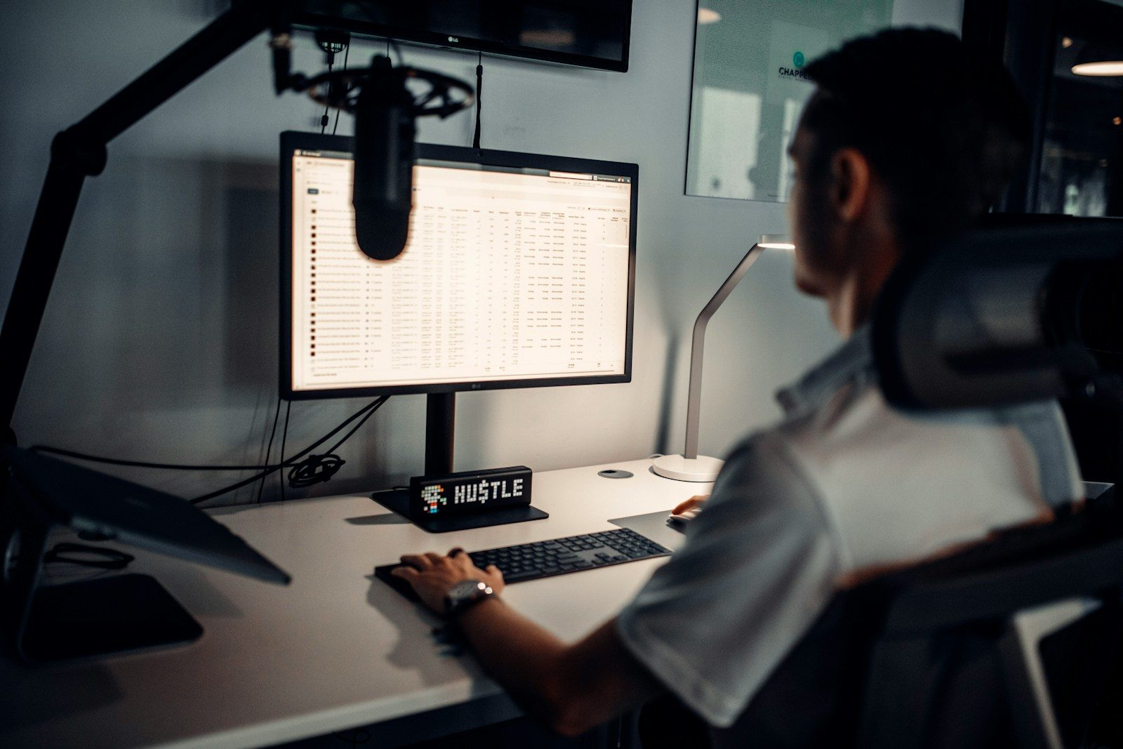 man in white polo shirt sitting in front of computer; voice AI endpointing