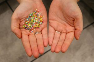 A hand with sprinkles and other without