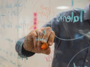 man writing on glass