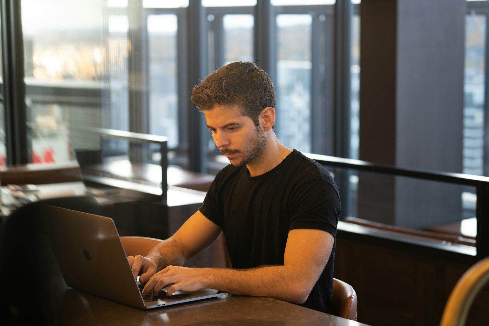 man in black crew neck t-shirt using macbook; PostgreSQL 19