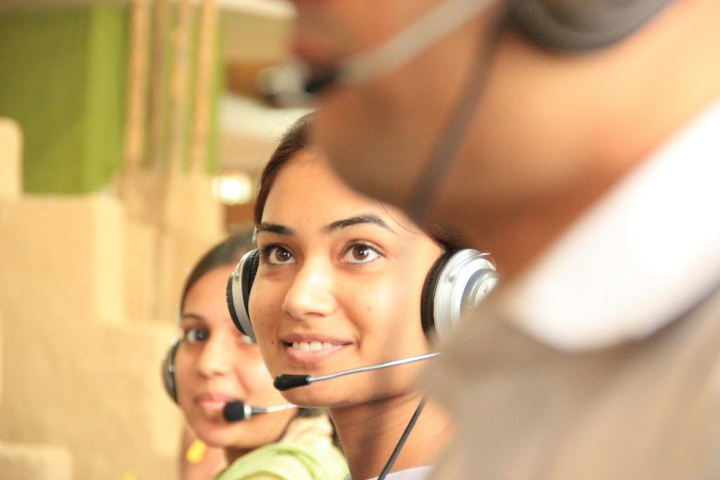 Two women wearing headsets in a bright office workspace; voice agent