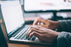 person using MacBook Pro; domain name