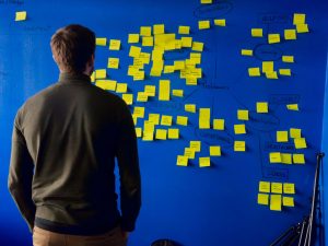 man looking at yellow sticky notes
