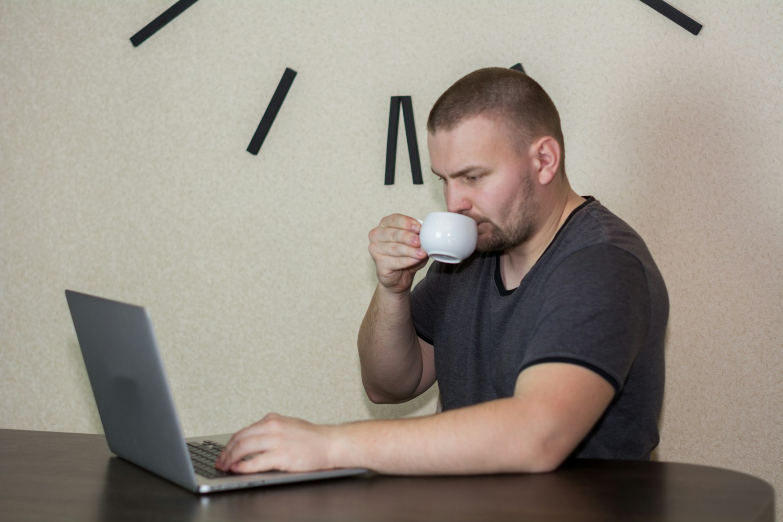 a man drinking a cup of coffee while using a laptop; how to use ai for content creation