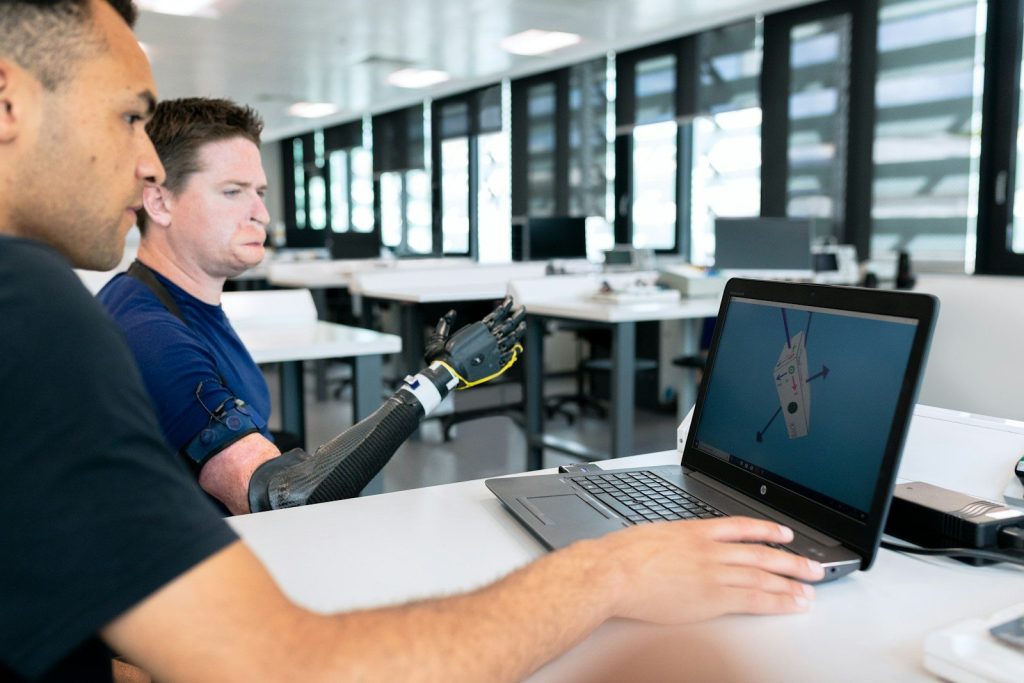 man in blue crew neck t-shirt using black laptop computer; hiring AI engineers