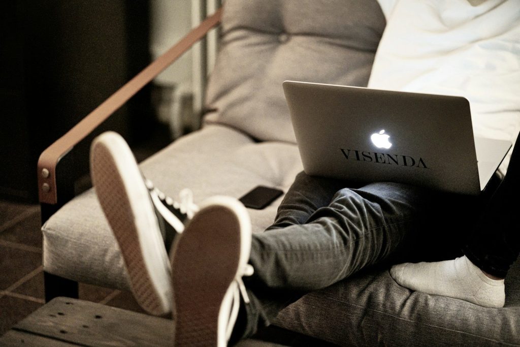 man in white long sleeve shirt and blue denim jeans sitting on brown sofa using macbook; Seedance 2.0 character consistency